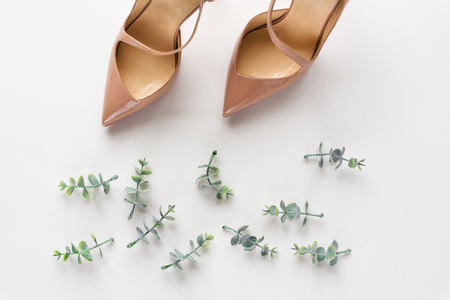 Bridal shoes with oregano branches on white marble. Top view.の写真素材