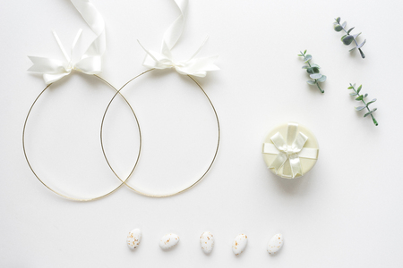 Wedding crowns, oregano branches, candys and box  on white marble. Top view.の写真素材