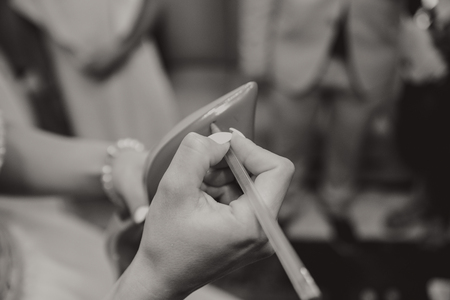 Bride writing the names of her friends under her shoesの写真素材