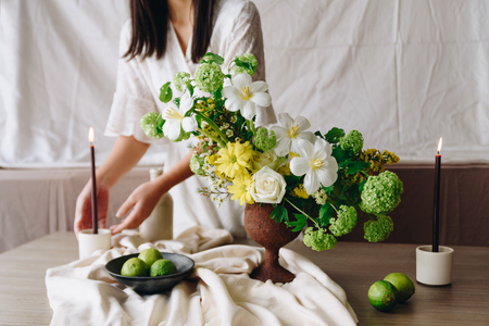 Woman touching candle. Still life with flower conceptの写真素材