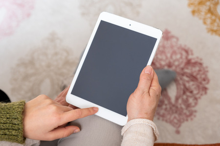 Adult woman and daughter using  tablet with blank screen.の写真素材