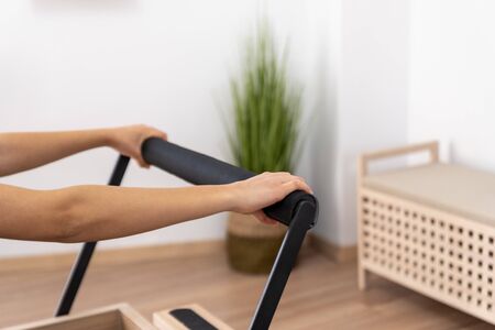 Young woman exercising on pilates reformer bed, hands close upの写真素材