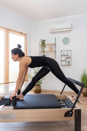Young woman exercising on pilates reformer bedの写真素材