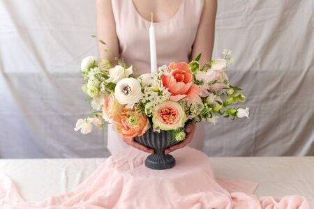 Woman holding vase full of flowers.の写真素材