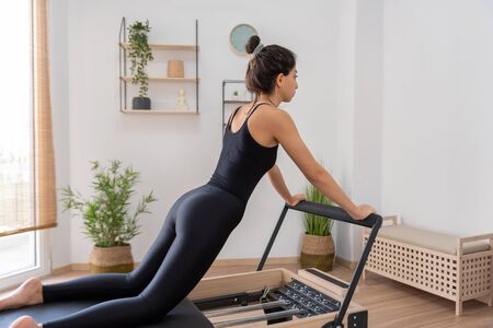 Young woman exercising on pilates reformer bedの写真素材