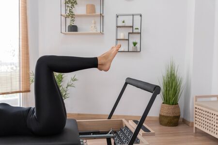 Young woman exercising on pilates reformer bedの写真素材