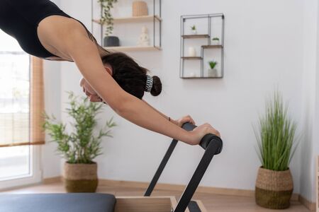 Young woman exercising on pilates reformer bedの写真素材