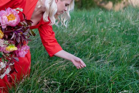 Woman's hand touching the grass at the fieldの写真素材