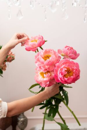 Hands of a young florist woman making modern bouquet of flowersの写真素材