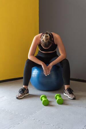 Sport woman sitting and resting after workout or exercise in fitness gym.の写真素材