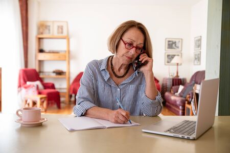 Middle age senior woman working at home using computer
