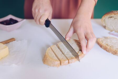 Woman cutting bread at  kitchenの写真素材
