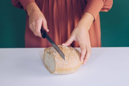 Woman cutting bread at  kitchenの写真素材