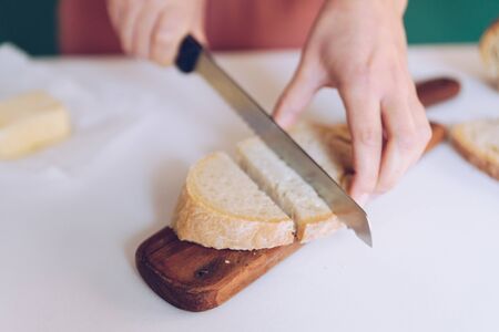 Woman cutting bread at  kitchenの写真素材