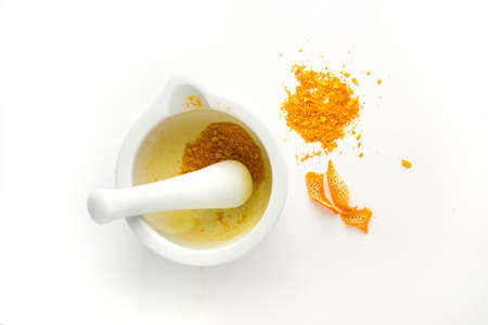 orange peel in a mortar on white background の写真素材