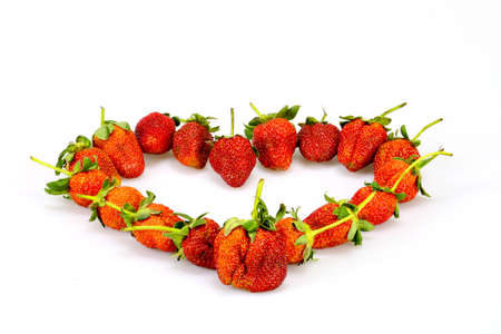 Strawberry  is placed into a heart shape on white background.の写真素材