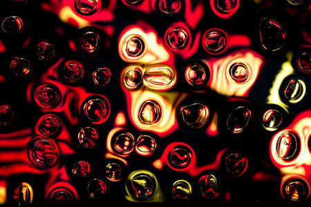 Oil and water droplets on a colorful background.