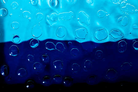 Oil and water droplets on a colorful background.の写真素材
