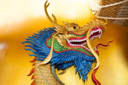 Dragon head sculpture on wall of temple in Thailandの写真素材