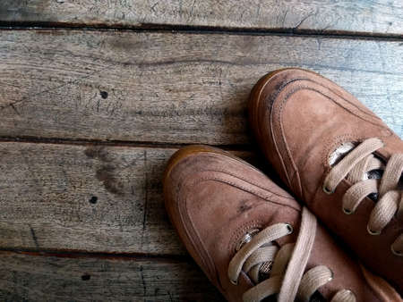 Old leather shoes with laces on a wooden background, retro, shoe repair