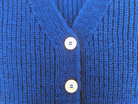 Background texture for knitting design, blue cardigan with English elastic band with wooden buttons, knitted by handの写真素材