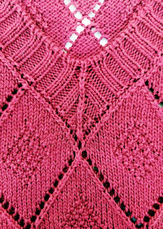 Background texture for knitting design, pink jumper with rhombuses, knitted by handの写真素材