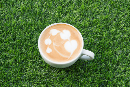 Coffee in white cup on the Artificial grass textureの写真素材