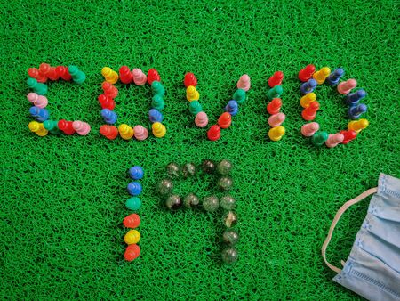 Inscription Covid-19 text made with game board pieces. Medical gloves, mask, sanitizers. Isolated on...
