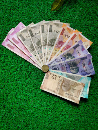 Set of 2000s,500s,200s,100s,50s,10s,and coins of indian rupees note isolated on green background.の写真素材