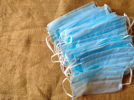 Bunch of antiviral medical mask for protection against corona virus. Isolated on gunny sack. Wear...
