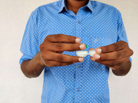 Man opening his contact lens box. Isolated on white background.