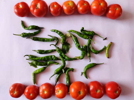 Bunch of tomatoes and green chillies isolated on white background. Selective focusの写真素材
