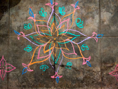 Colorful flower kolam drawn using color chalk pieces. In front of south indian home. Festival time conceptの写真素材