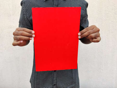 Young man in black shirt holding a blank red color chart or board or paper. Isolated on white...