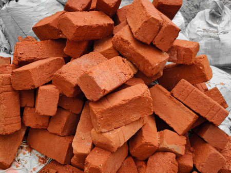 Stack of red bricks in construction site. Outdoors. Daylight condition