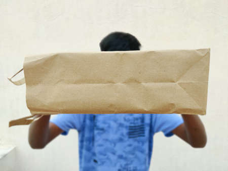 South Indian young man giving shopping bag. Delivering gifts concepts
