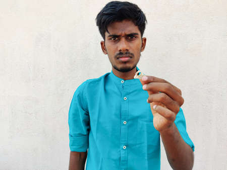 South Indian young man holding a bird skull.Isolated on white background.の写真素材