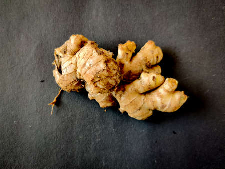 Large piece of fresh Ginger on a black background. Selective focus
