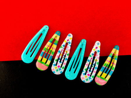 Three set of colorful patterns of hair clips isolated on red and black background. Trendy beauty...