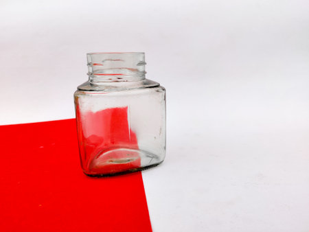 Empty glass jar on red sheet. Isolated on white background.の写真素材