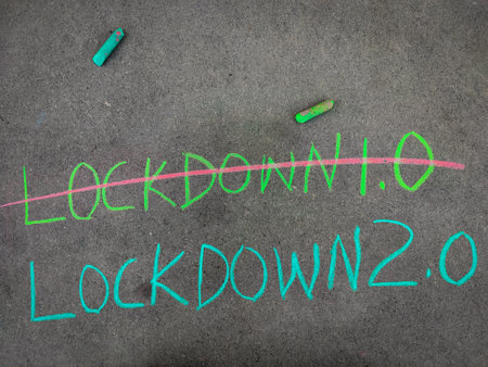The inscription text on the grey board, strike out lockdown 1.0 and lockdown 2.0 Using color chalk pieces.の写真素材