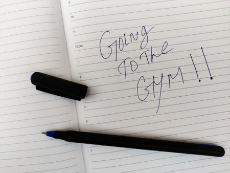 A Daily diary with text GOING TO THE GYM!! and pen.の写真素材