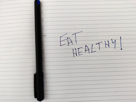 A Daily diary with text EAT HEALTHY! and pen.の写真素材