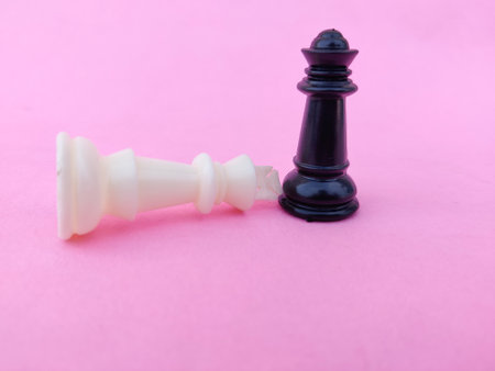 White chess king surrender to black chess queen. Pink backgroundの写真素材