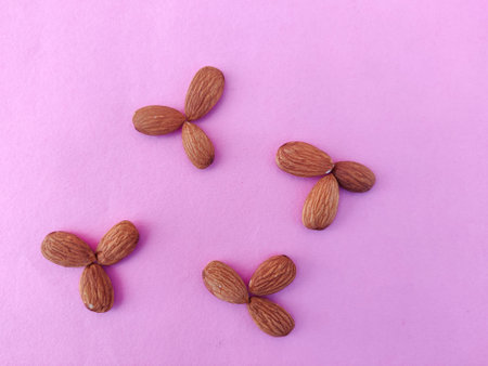 Collection of Almonds placed like flower shaped. Isolated on pink background.の写真素材