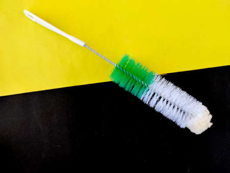 Top view of a brush with sponge and hairs used to clean water bottle.Isolated on Yellow and black backgroundの写真素材