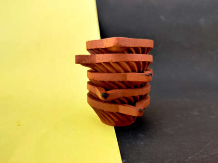 A stack of five Clay lamps or diya or oil lamps one over other. Indian type.Isolated on yellow and...