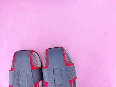 Copy space of one pair of grey and red color men sandals or slipper isolated on pink backgroundの写真素材