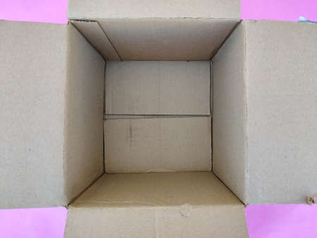 Top view of empty cart board box or brown box isolated on pink background