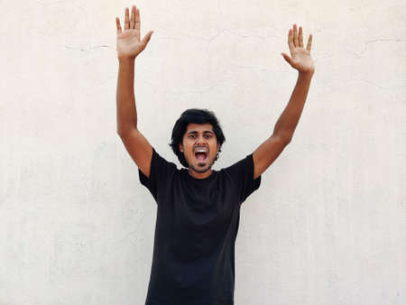 Portrait of nice attractive charming cheerful long haired man rising hands up celebrating. Isolated on white backgroundの写真素材